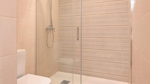 Second bathroom with glass shower enclosure and toilet