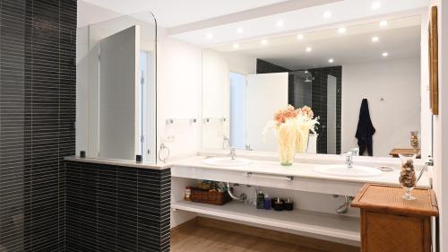 Bathroom with double vanity and dark-tiled walk-in shower