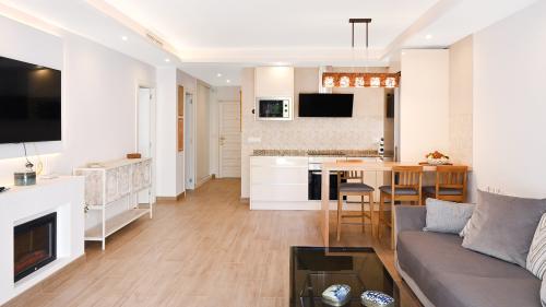 Open-plan living area with fireplace, TV, dining table and kitchen