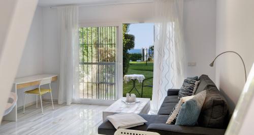 Wohnzimmer mit Terrassentür zu Garten und Meer