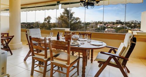 Überdachte Terrasse mit für sechs Personen gedecktem Esstisch und Blick über die Gartenanlage