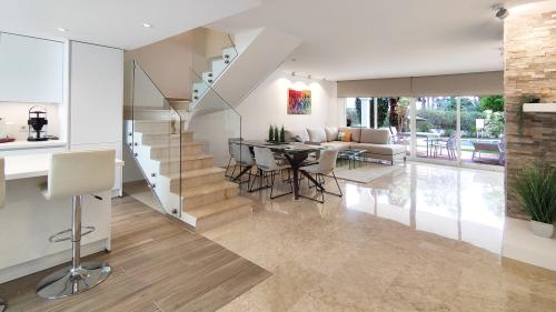 Essbereich mit Glastreppe und Wohnzimmer mit Meerblick