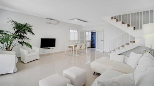 Wohnzimmer mit Sessel, TV und Esstisch, Gartenblick