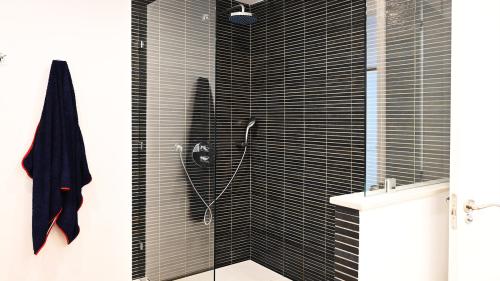 Walk-in shower with rainfall showerhead and dark mosaic tiling