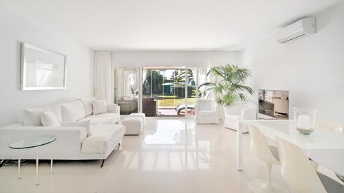 Wohnzimmer mit weißem Sofa und Schiebetüren zur Terrasse