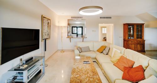 Wohnzimmer mit Sofa, Wand-TV und Vitrine