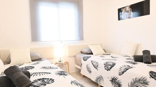 Zweibettzimmer mit Tagesdecken im tropischen Blattmuster