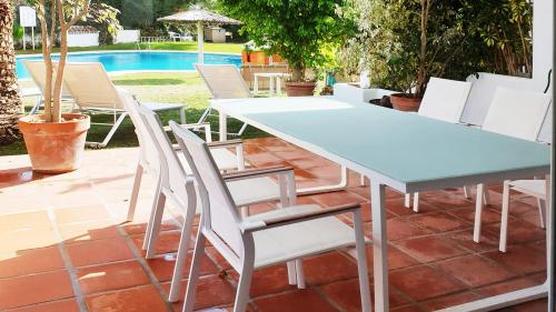 Terrasse mit Esstisch im Freien mit Blick auf Garten und Pool