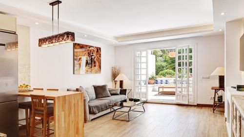 Open-plan living, dining and kitchen area with sofa, artwork and terrace access