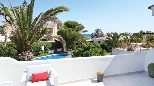Dachterrasse mit Sonnenliege mit Blick auf den Gemeinschaftspool und das Meer