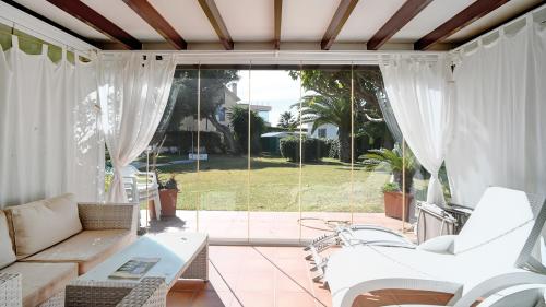 Überdachte Terrasse mit Sofa-Sitzecke mit Blick auf den Garten