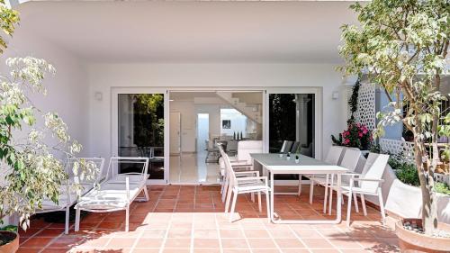 Überdachte Terrasse mit Esstisch und Loungebett