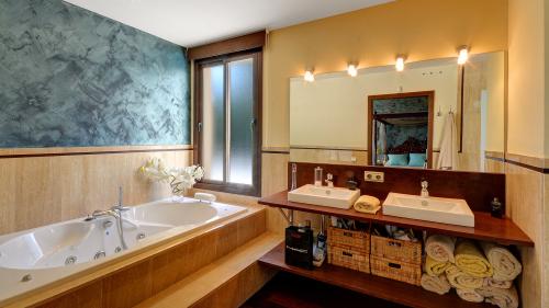 Hauptbadezimmer mit Whirlpoolwanne und Doppelwaschbecken