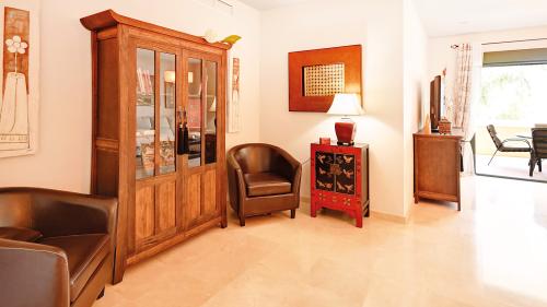 Sitting area with wooden display cabinet, leather armchairs and decorative mirror